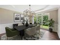 Virtually staged dining room with modern light fixture, stylish decor, and large windows at 4685 Braselton Hwy, Hoschton, GA 30548
