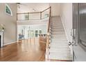 Bright and airy living room with hardwood floors, fireplace, a staircase to the second story, and open access to dining room at 1605 Spinnaker Drive, Alpharetta, GA 30005