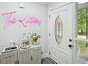 Bright entryway with white door, decorative glass, and stylish decor on gray wooden cabinet at 5077 Martindale Ln, Stone Mountain, GA 30088