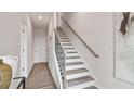 Inviting hallway with stairs, wood floors, and white door at 1309 Lakota Pl # 17, Atlanta, GA 30315
