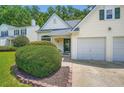 Close up of a charming home showcasing verdant landscaping and a convenient two-car garage at 181 Weatherstone Dr, Woodstock, GA 30188