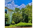 Exterior corner view of a beautiful condo surrounded by lush green trees and landscaping at 1428 Orchard Park Dr, Stone Mountain, GA 30083