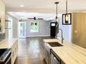 Open-concept kitchen featuring a marble island connecting to the living area with hardwood floors at 2625 Semmes St, Atlanta, GA 30344