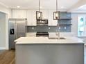 Bright kitchen with a gray island, stainless appliances, and contemporary pendant lighting at 2625 Semmes St, Atlanta, GA 30344