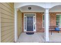 A welcoming front porch with a black door, complemented by brick accents and comfortable seating at 4092 Duran Ln, Auburn, GA 30011