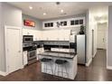 Modern kitchen with white cabinets, stainless steel appliances, black countertops, and a stylish island at 560 Dutch Valley Road # 2412, Atlanta, GA 30324