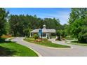 Gated community entrance with meticulously maintained landscaping, mature trees, and classic gatehouse design at 782 Brooke View Drive, Canton, GA 30115