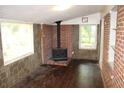 Cozy living room with a brick fireplace, wood-look floors, and abundant natural light at 8469 Shiloh Ct, Jonesboro, GA 30238