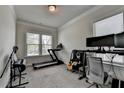 Versatile room with large windows, carpeted floor, and crown molding, used as a home gym and music room at 1045 Penny Ln, Roswell, GA 30076