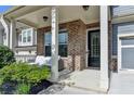 Inviting front porch featuring brick accents and a cozy outdoor seating area, perfect for relaxing at 1045 Penny Ln, Roswell, GA 30076