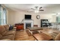 Cozy living room with fireplace, ceiling fan, and wood-look flooring at 45 Ratliff Dr, Covington, GA 30016