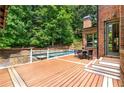 Large deck featuring a dining area, outdoor access, and a view of the in-ground pool at 908 Basingstoke Ct, Suwanee, GA 30024