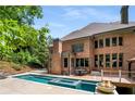 Luxury backyard with a rectangular pool, hot tub, fire pit, deck and a full brick exterior at 908 Basingstoke Ct, Suwanee, GA 30024