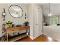 Inviting entryway with wooden floors, complemented by a rustic table and bright, open living space at 418 Whisper Wood Way, Locust Grove, GA 30248