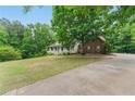 Beautiful home with a spacious lawn and mature trees offering plenty of shade at 418 Whisper Wood Way, Locust Grove, GA 30248