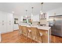 Well-lit kitchen features an island with seating, stainless steel appliances, and sleek white cabinetry at 3222 Edgemont Way, Decatur, GA 30032