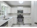 Bright kitchen boasts stainless steel appliances, white cabinets, and modern countertops for a sleek, functional design at 49 Sweetwater Ct, Powder Springs, GA 30127