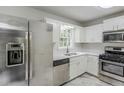 Bright kitchen boasts stainless steel appliances, white cabinets, and modern countertops for a sleek, functional design at 49 Sweetwater Ct, Powder Springs, GA 30127
