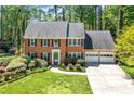Charming brick home with a well-manicured lawn, mature trees, and an attached two-car garage at 2830 Scottish Mill Way, Marietta, GA 30068