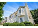 View of the home's exterior with a bay window, manicured bushes, and blue sky at 7835 Teton Trl, Douglasville, GA 30134