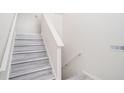 Neutral stairway with gray plank flooring and white trim at 7835 Teton Trl, Douglasville, GA 30134