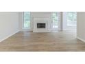 Bright living room features a white brick fireplace, hardwood floors, and access to outdoor deck at 10 Mariner Se Way, Acworth, GA 30102