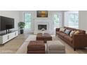Bright living room features a white brick fireplace, hardwood floors, and a comfortable brown leather sofa at 10 Mariner Se Way, Acworth, GA 30102