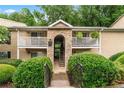 Condo building with multiple units, patios, mature trees, and easy access via exterior stairs at 3115 Seven Pines Ct # 308, Atlanta, GA 30339
