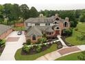 Aerial view of the home featuring meticulous landscaping, lush tree coverage, and circular driveway at 794 Rutland Ct, Lithonia, GA 30058