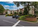Exterior angle view of a brick building with lush landscaping and plenty of parking at 825 Highland Lane Northeast Ne # 1313, Atlanta, GA 30306
