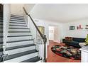 Bright living room boasts a striking staircase, hardwood floors, and stylish decor, offering a comfortable living space at 6940 Roswell Road Rd # 16B, Atlanta, GA 30328