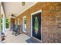 Inviting front porch with brick detailing, rocking chairs, and a welcoming entryway at 705 S Bethany Rd, Mcdonough, GA 30252