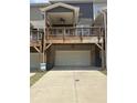 Rear view of townhome with a two-car garage, wooden deck, and a concrete driveway at 559 Fundao Ln # 21, Lawrenceville, GA 30046