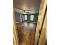 Spacious bedroom with new wood flooring, two windows, and a ceiling fan at 5768 Windgate Ln, Lithonia, GA 30058