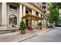 Exterior of building featuring a covered entrance, decorative architecture, and mature trees at 75 Ponce De Leon Ne Ave # 1006, Atlanta, GA 30308