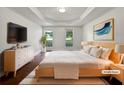 Bright bedroom featuring tray ceilings, large windows, and stylish modern furniture at 643 Windy Mill Way, Temple, GA 30179