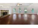 Spacious living room featuring hardwood floors, a ceiling fan, and a stone fireplace at 643 Windy Mill Way, Temple, GA 30179