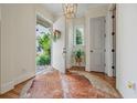 Bright foyer with a stylish cowhide rug, a view of the front garden, and an elegant light fixture at 6930 Wesley Hughes Rd, Cumming, GA 30040