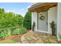 Inviting front door with a wreath, flanked by potted plants and complemented by lush greenery at 6930 Wesley Hughes Rd, Cumming, GA 30040