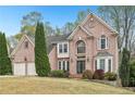 Charming brick home with a well-manicured lawn and beautiful landscaping at 3887 Hickory Manor Dr, Suwanee, GA 30024