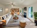 Bright living room with a fireplace, large windows, modern furniture, and neutral decor at 46 Timber Walk Dr, Sharpsburg, GA 30277