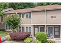 Exterior of a cozy townhome with a well-manicured landscape including shrubs and blooming crepe myrtle at 1810 Ashborough Se Rd # G, Marietta, GA 30067