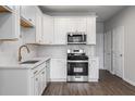 Bright kitchen featuring white cabinets, stainless steel appliances, and modern fixtures at 50 Black Gum Lot 49 Ln, Auburn, GA 30011