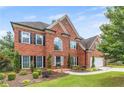 Beautiful two-story brick home with a well-manicured lawn and mature landscaping at 1219 Hadaway Ct, Lawrenceville, GA 30043