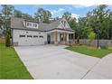 Charming two-story home featuring a manicured lawn, craftsman architecture, and a two-car garage at 153 Alaina Rd, Holly Springs, GA 30115