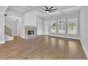 Bright, open living room featuring a cozy fireplace, coffered ceilings, and large windows at 153 Alaina Rd, Holly Springs, GA 30115