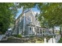 Side view of a gray two-story home with a welcoming porch and landscaped yard at 207 E Hightower E Trl, Social Circle, GA 30025