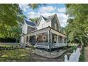 Side view of a lovely two-story house with a spacious wrap-around porch and manicured lawn at 207 E Hightower E Trl, Social Circle, GA 30025