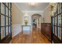 Elegant foyer boasts hardwood floors, detailed trim, and an arched doorway leading to a cozy living space with a fireplace at 3502 Village Green Dr, Roswell, GA 30075