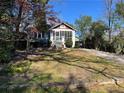 Home with a screened porch situated on a grassy lot with mature trees and a stone retaining wall at 284 Lakeview Ne Ave, Atlanta, GA 30305